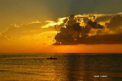 sunrise and a fisherman paddling out hoping for a good ca... by Shawn Jackson 